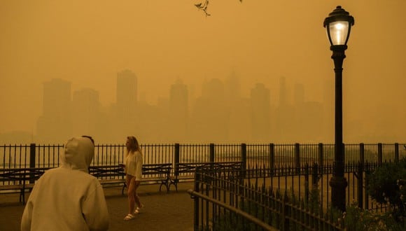 El horizonte del bajo Manhattan se ve más allá de los peatones mientras el humo de los incendios forestales en Canadá causan condiciones de niebla en la ciudad de Nueva York el 7 de junio de 2023 (Foto: Angela Weiss / AFP)