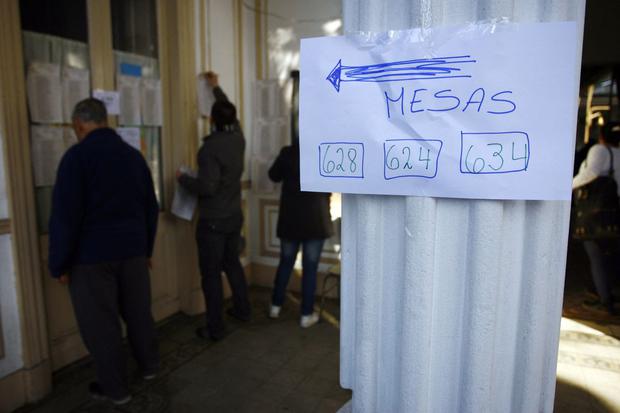 Los ciudadanos buscan sus nombres en el registro electoral antes de votar en un colegio electoral en las afueras de Buenos Aires, el 14 de agosto de 2011 (Foto: Maxi Failla / AFP)