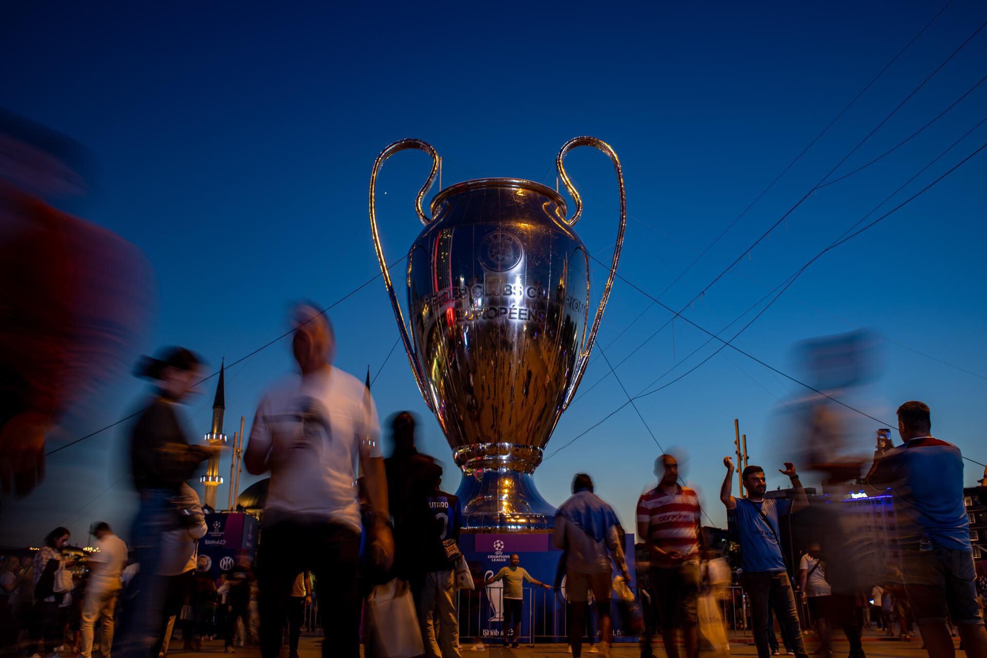 Istanbul (Turkey), 09/06/2023.- People walk past a huge model of the UEFA Champions League trophy backdropped by the Taksim Mosque in the Taksim Square in Istanbul, Turkey, 09 June 2023. Inter Milan faces Manchester City in the UEFA Champions League Final in Istanbul on 10 June 2023. (Liga de Campeones, Turquía, Estanbul) EFE/EPA/MARTIN DIVISEK
