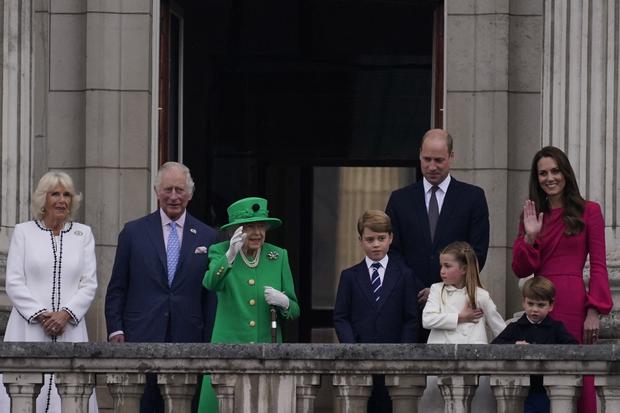 La reina Isabel II de Gran Bretaña (3ra L) saluda a la multitud mientras está de pie en el balcón del Palacio de Buckingham con (De izquierda a derecha) Camilla de Gran Bretaña, Duquesa de Cornualles, Príncipe Carlos de Gran Bretaña, Príncipe de Gales, Príncipe George de Cambridge de Gran Bretaña, Príncipe William de Gran Bretaña, Duque of Cambridge, la princesa Charlotte de Cambridge de Gran Bretaña, Catherine, duquesa de Cambridge de Gran Bretaña y el príncipe Louis de Cambridge de Gran Bretaña al final del concurso de platino en Londres el 5 de junio de 2022 como parte de las celebraciones del jubileo de platino de la reina Isabel II. (Foto de Alberto Pezzali / PISCINA / AFP)