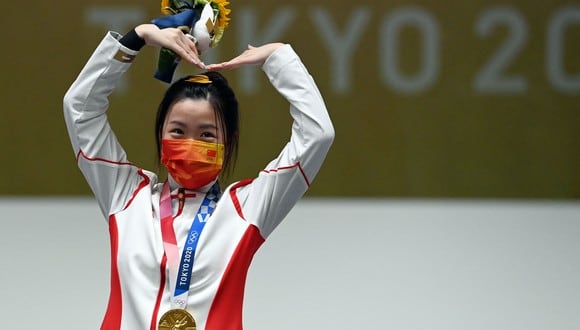 Gold medal winner China's Yang Qian celebrates on the podium after winning the women's 10m air rifle final during the Tokyo 2020 Olympic Games at the Asaka Shooting Range in the Nerima district of Tokyo on July 24, 2021. (Photo by Tauseef MUSTAFA / AFP)
