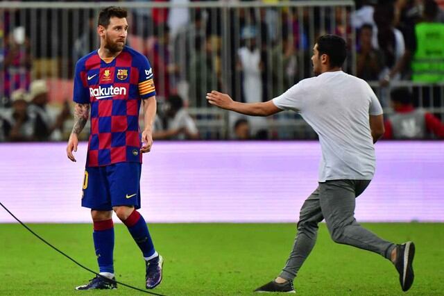 Lionel Messi y el tenso momento vivido con un fanático que saltó a la cancha. (Foto: AFP)