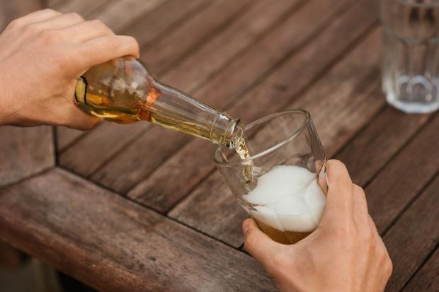 A person pours beer into a glass. (Photo: Pexels)