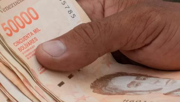 En esta imagen de archivo, tomada el 5 de agosto de 2021, un hombre cuenta billetes por el equivalente a un dólar en una parada de ómnibus en Caracas, Venezuela. (Foto: AP /Ariana Cubillos, archivo)