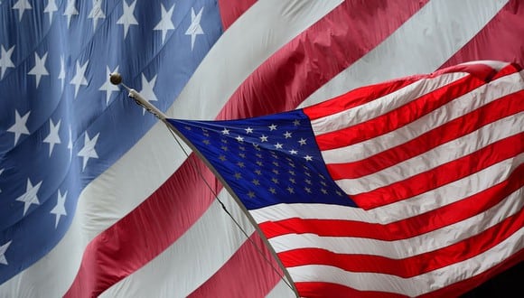 Una bandera de Estados Unidos ondea frente a otra gran bandera en Nueva York. (Foto de Emmanuel DUNAND / AFP).