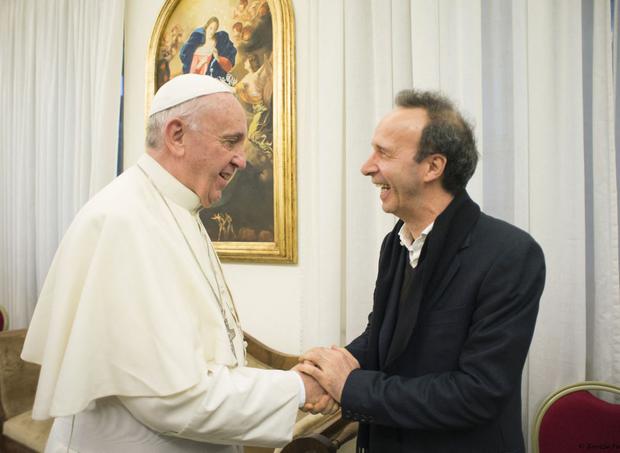 El Papa Francisco dando la bienvenida al actor y director de cine italiano Roberto Benigni, mientras recibe su nuevo libro "El nombre de Dios es Misericordia" en el Vaticano, el 11 de enero de 2016 (Foto: Osservatore Romano / AFP)