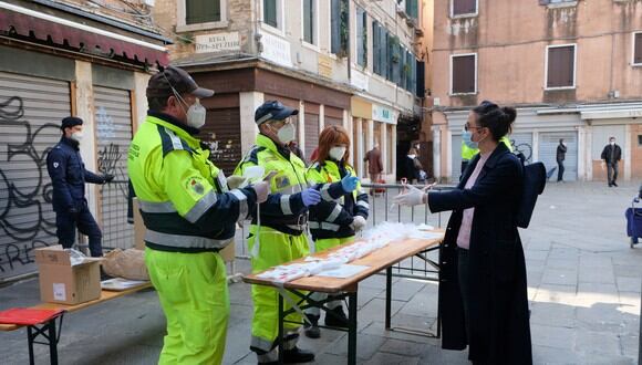 Trabajadores reparten mascarillas en Italia. (Foto: Reuters)