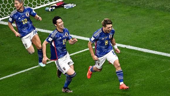 Japan's midfielder #08 Ritsu Doan (R) celebrates scoring his team's first goal during the Qatar 2022 World Cup Group E football match between Germany and Japan at the Khalifa International Stadium in Doha on November 23, 2022. (Photo by Anne-Christine POUJOULAT / AFP)