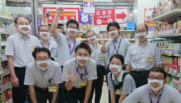 Los trabajadores usan mascarillas con sonrisas impresas para alegrar a clientes. (Foto: @takeya_co_jp / Twitter)