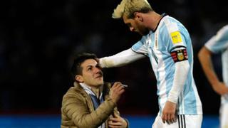 Lionel Messi y un nuevo hincha que ingresó al campo de juego para abrazarlo