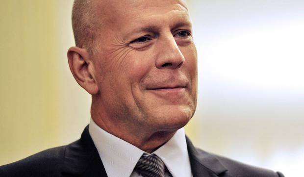 Bruce Willis al escuchar que fue galardonado como "Comandante de la Orden de las Artes y las Letras" por el ministro de Cultura francés el 11 de febrero de 2013 (Foto: Mehdi Fedouach / AFP)
