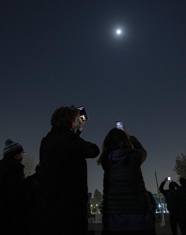 Personas toman fotografías de un eclipse total de Luna. (Foto: AFP)