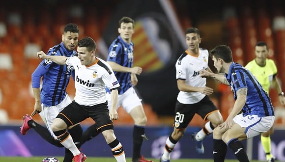 Valencia's Kevin Gameiro, left, controls the ball during the Champions League round of 16 second leg soccer match between Valencia and Atalanta in Valencia, Spain, Tuesday March 10, 2020. The match is being in an empty stadium because of the coronavirus outbreak. (UEFA via AP)