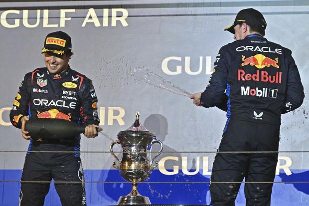 First placed Red Bull Racing's Dutch driver Max Verstappen (R) and second placed Red Bull Racing's Mexican driver Sergio Perez celebrate during the podium ceremony of the Bahrain Formula One Grand Prix at the Bahrain International Circuit in Sakhir on March 2, 2024. (Photo by ANDREJ ISAKOVIC / AFP)