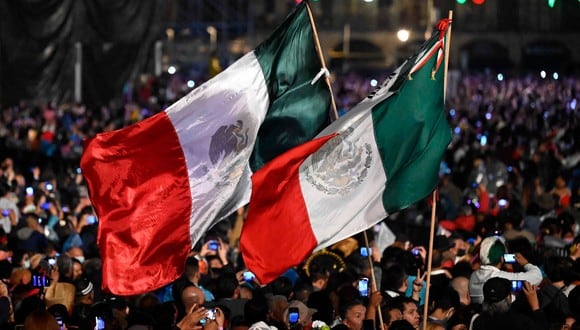 Varias personas durante la ceremonia "El Grito" que marca el inicio de las celebraciones del Día de la Independencia en la plaza del Zócalo en Ciudad de México. (Foto: AFP)