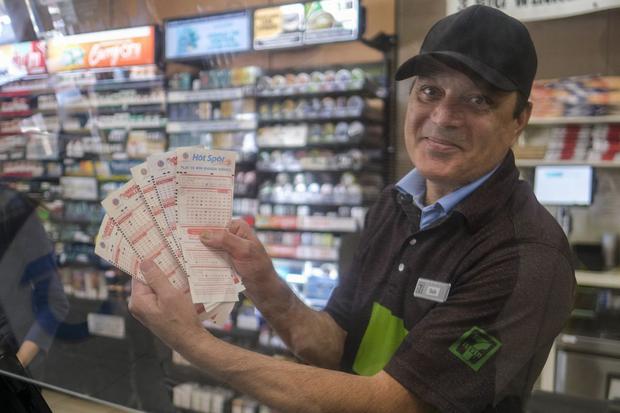Un cajero muestra boletos de lotería Mega Millions en una tienda de conveniencia 7-Eleven en Chino Hills, California (Foto: AFP)