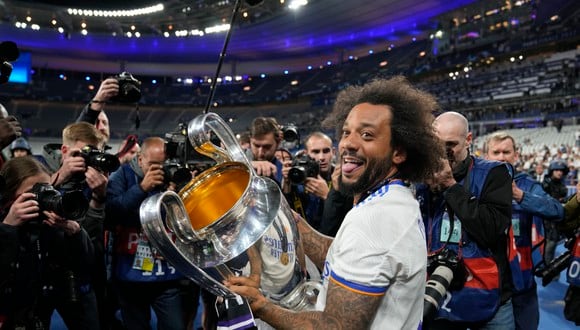 Real Madrid's Marcelo holds the trophy while celebrating with team mates winning the Champions League final soccer match between Liverpool and Real Madrid at the Stade de France in Saint Denis near Paris, Sunday, May 29, 2022. (AP Photo/Frank Augstein)