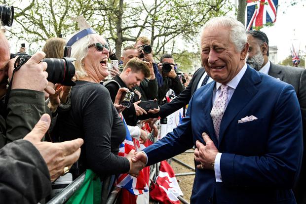 El rey Carlos III saluda en la vía The Mall, cerca del Palacio de Buckingham, a cientos de ciudadanos que llegaron a presenciar su coronación. (Foto: TOBY MELVILLE / AFP)