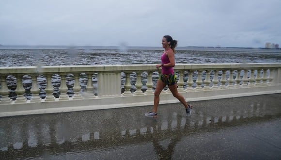 Una mujer trota a lo largo de Bayshore Boulevard mientras la marea retrocede desde Tampa Bay cuando se acerca el huracán Ian el 28 de septiembre de 2022 en Tampa, Florida.  (Foto de Bryan R. Smith / AFP)