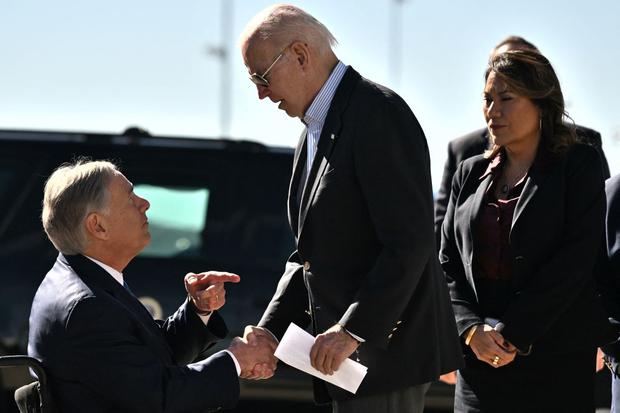 El gobernador republicano por Texas, Greg Abbott, saludando al presidente de Estados Unidos, Joe Biden, a quien critica por su política migratoria (Foto: AFP)