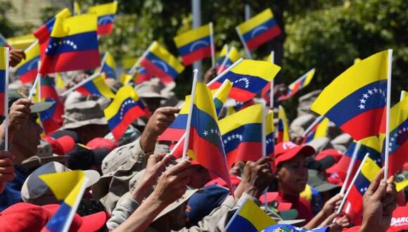 Los partidarios del presidente venezolano Nicolás Maduro ondean banderas nacionales cuando se reúnen para conmemorar el vigésimo aniversario del ascenso del poder del difunto Hugo Chávez. (Foto: AFP)
