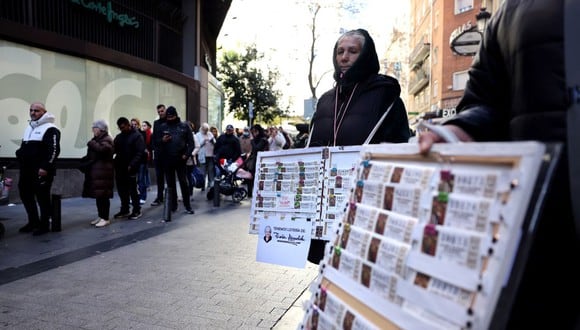Los vendedores ambulantes que ofrecen billetes de lotería de Navidad frente al popular establecimiento de lotería 'Dona Manolita' el 18 de diciembre de 2023 en el centro de Madrid (Foto: Thomas Coex / AFP)