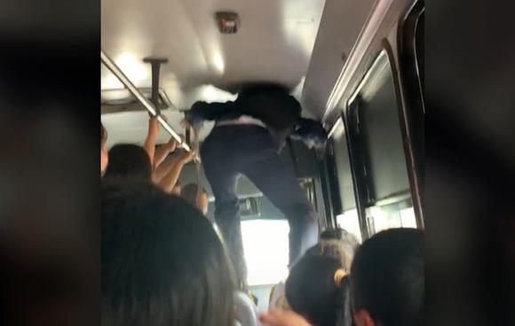 A young man goes viral for climbing onto the seats of a bus to be able to get off at his whereabouts (Video: TikTok/@viiicluna).
