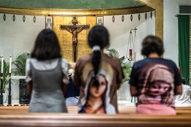 Los feligreses acuden a rezar en el Día de Todos los Santos, como en el caso de estas personas en la iglesia católica de San José, en Florida  (Foto de Giorgio Vera/ AFP)