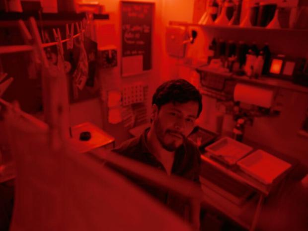 Harold Torres como Santiago en un cuarto para revelar fotografías en la la película “Desaparecer por completo” (Foto: Varios Lobos)