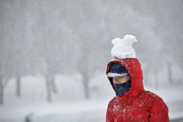 Un hombre caminando con un poco de nieve en la cabeza (Foto: AFP)