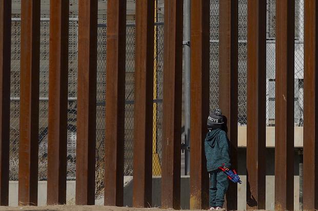 Un migrante venezolano George, de 5 años, se para junto a los barrotes del muro fronterizo en Ciudad Juárez, estado de Chihuahua, México (Foto: Herika Martínez / AFP)