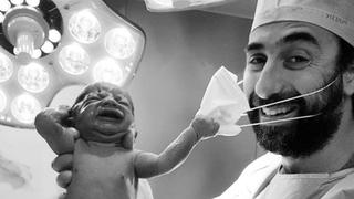 El momento en que un recién nacido le quita la mascarilla al doctor que lo trajo al mundo