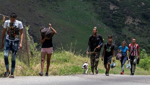 Un grupo de migrantes venezolanos camina por la carretera entre San Cristóbal y la ciudad fronteriza de San Antonio del Táchira para cruzar la frontera con Colombia y continuar su viaje hacia Estados Unidos. (YURI CORTEZ / AFP).