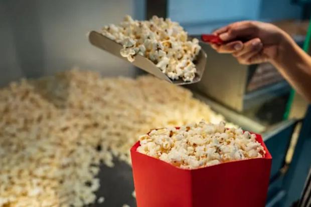 En el cine, sirviendo una caja de pop corn salado (Foto: ShutterStock)