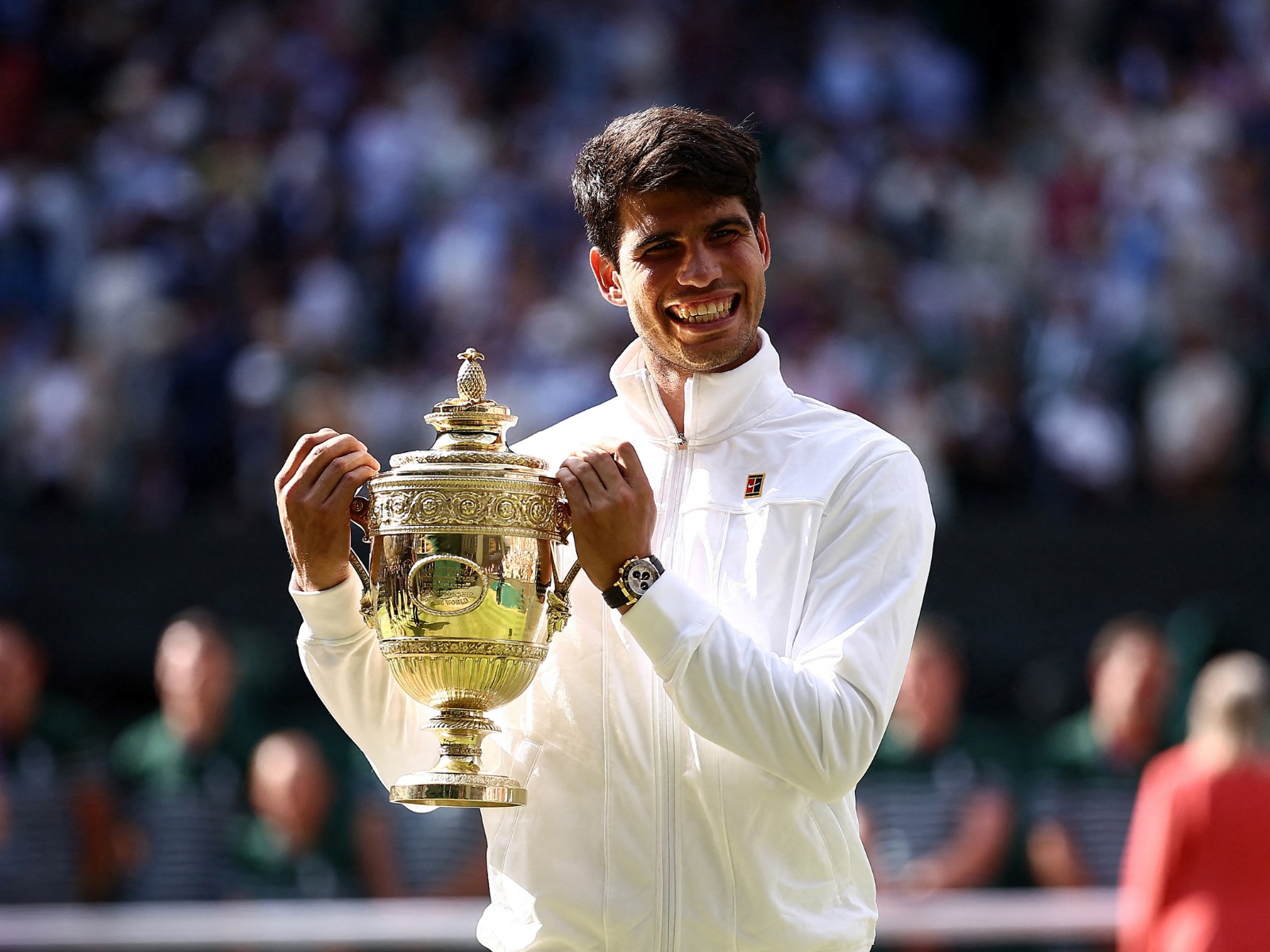 El español Carlos Alcaraz posa con el trofeo de ganador tras vencer al serbio Novak Djokovic durante su partido de tenis final individual masculino en la decimocuarta jornada de los Campeonatos de Wimbledon 2024 en The All England Lawn Tennis and Croquet Club en Wimbledon, suroeste de Londres, el 14 de julio de 2024. Alcaraz, defensor del título, se impuso al siete veces ganador Novak Djokovic en una final de infarto, en la que Alcaraz se impuso por 6-2, 6-2 y 7-6. | Crédito: Henry Nicholls / AFP