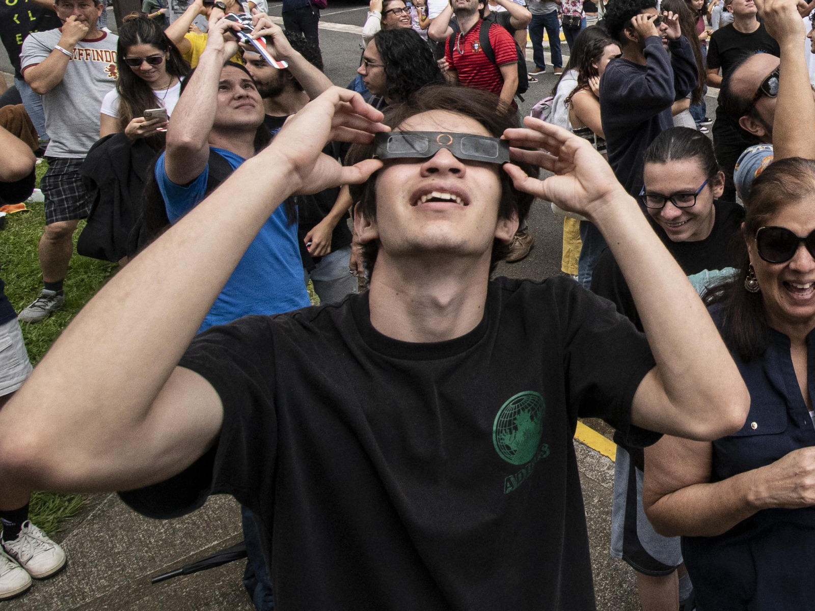 Un joven protegiendo su vista con unos lentes especiales mientras observa un eclipse solar (Foto: AFP)