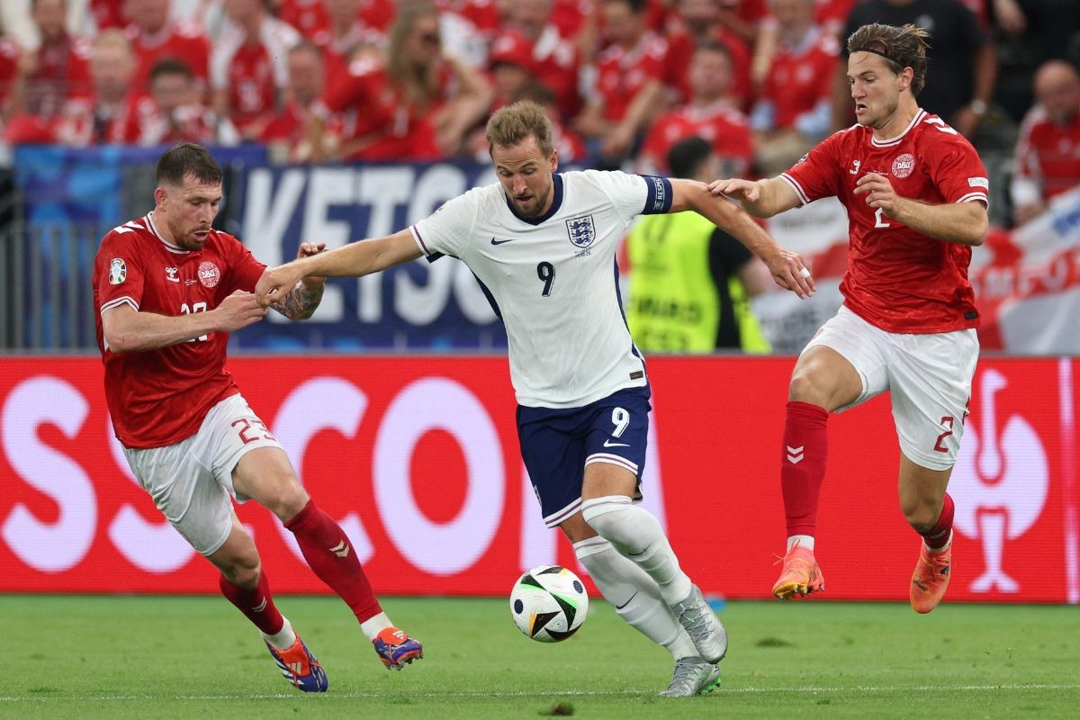 England's forward #09 Harry Kane (C), Denmark's midfielder #23 Pierre-Emile Hojbjerg and Denmark's defender #02 Joachim Andersen fight for the ball during the UEFA Euro 2024 Group C football match between Denmark and England at the Frankfurt Arena in Frankfurt am Main on June 20, 2024. | Photo by Adrian Dennis / AFP