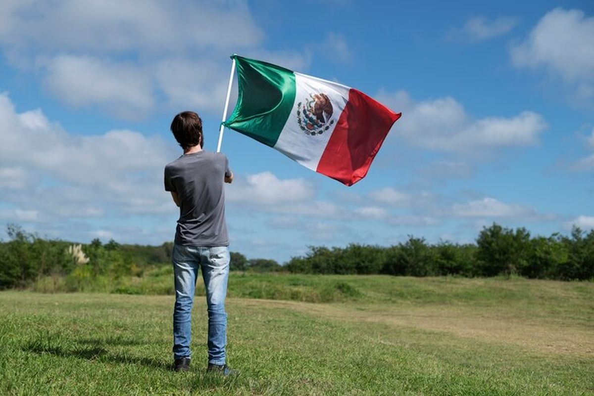 Un joven disfrutando de su feriado en México. Él lleva la bandera de su país (Foto: Freepik)