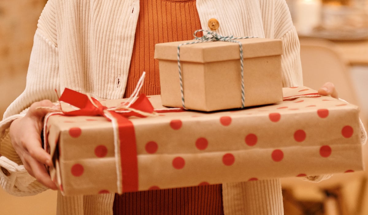 Niña sostiene sus regalos de Día de Reyes (Foto: Nicole Michalou / Pexels)