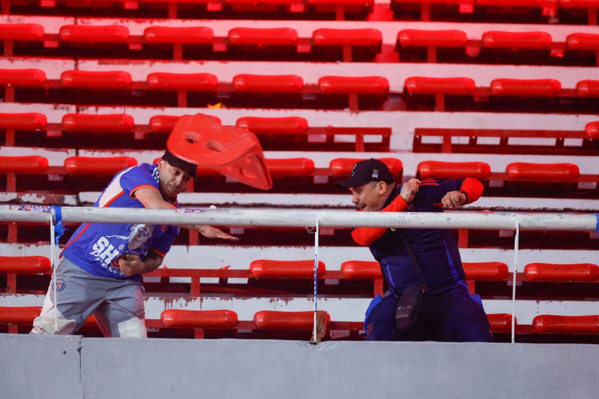 AMDEP1467. AVELLANEDA (ARGENTINA), 20/08/2025.- Hinchas se enfrentan en una tribuna este miércoles, en un partido de los octavos de final de la Copa Sudamericana entre Independiente y Universidad de Chile en el estadio Libertadores de América en Avellaneda (Argentina). EFE/ Juan Ignacio Roncoroni