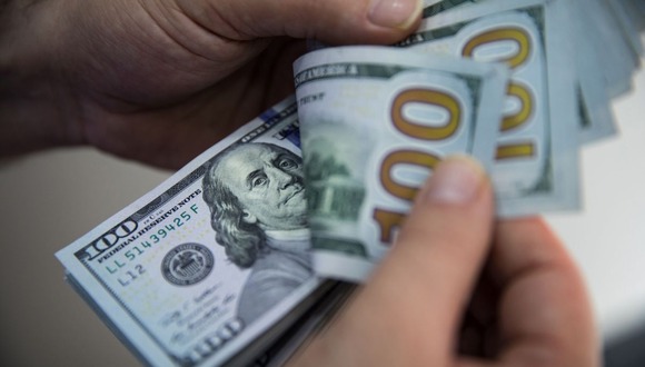 A man counts a bundle of U.S. one-hundred dollar bills in Turkey. Photographer: Bloomberg Creative Photos/Bloomberg