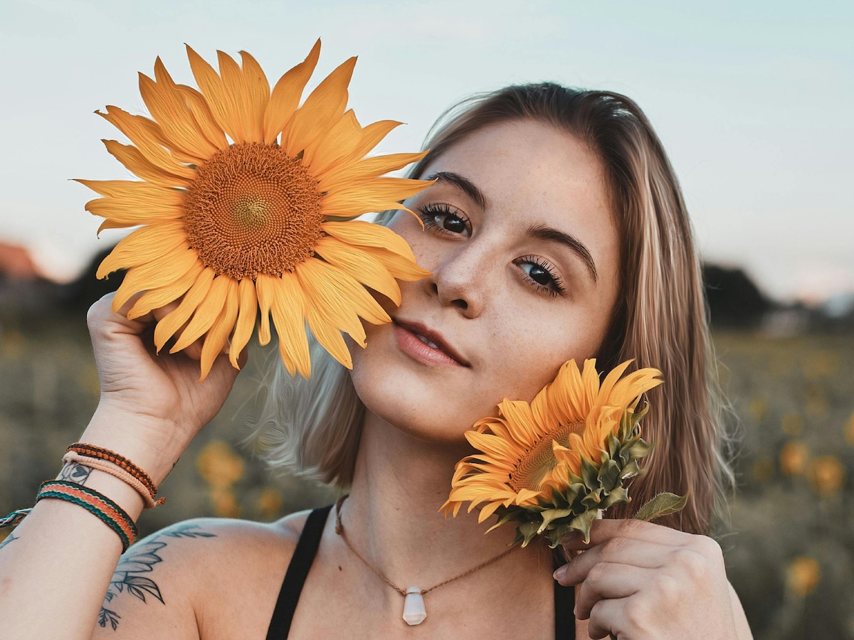 Una joven sujetando unos grandes girasoles (Foto: Pexels)