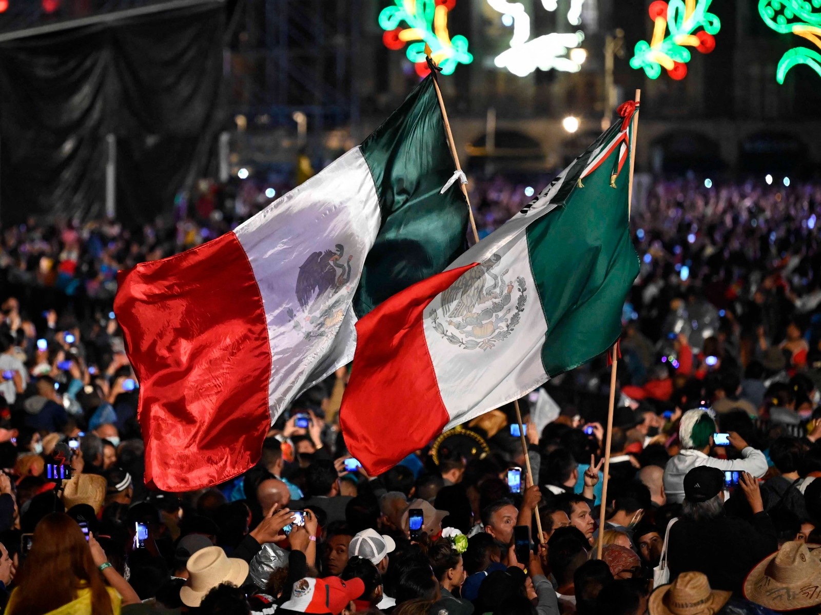 Varias personas durante la ceremonia "El Grito" que marca el inicio de las celebraciones del Día de la Independencia en la plaza del Zócalo en Ciudad de México. (Foto: AFP)