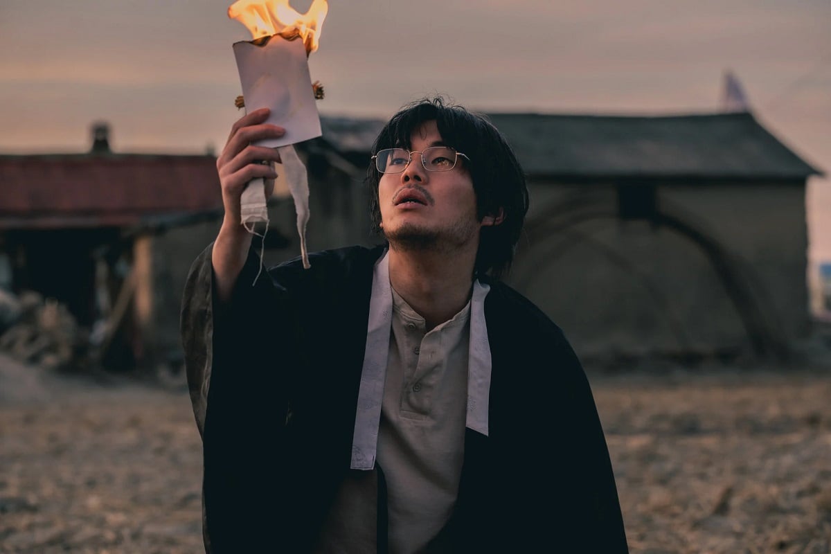 El supuesto medio hermano de la protagonista de la serie coreana "El legado" quemando una fotografía (Foto: Netflix)