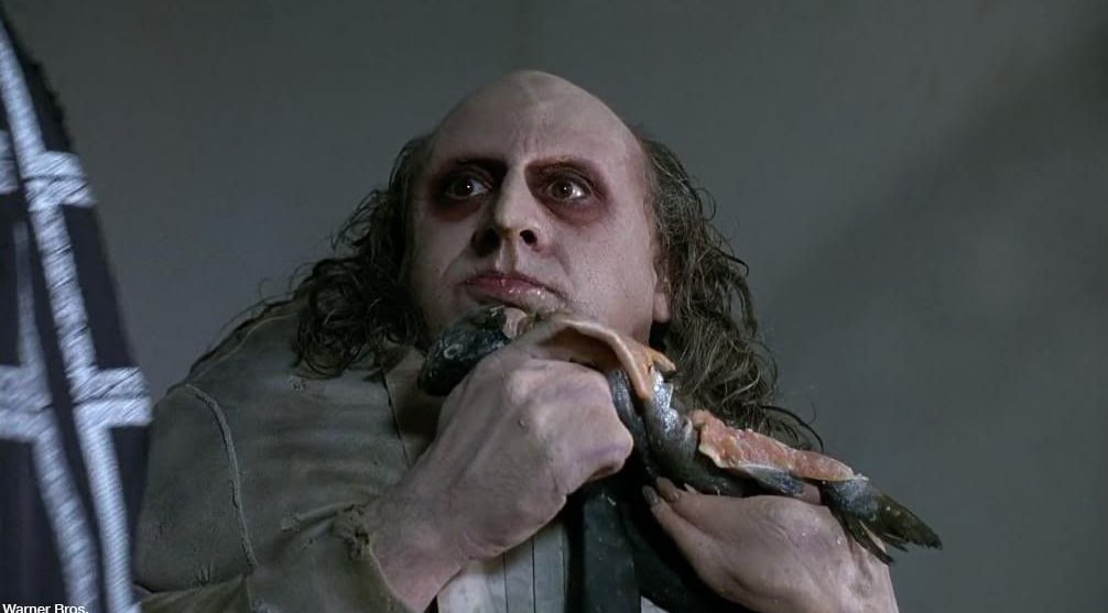 El Pingüino comiendo pescado crudo en "Batman regresa" (Foto: Warner Bros. Pictures)