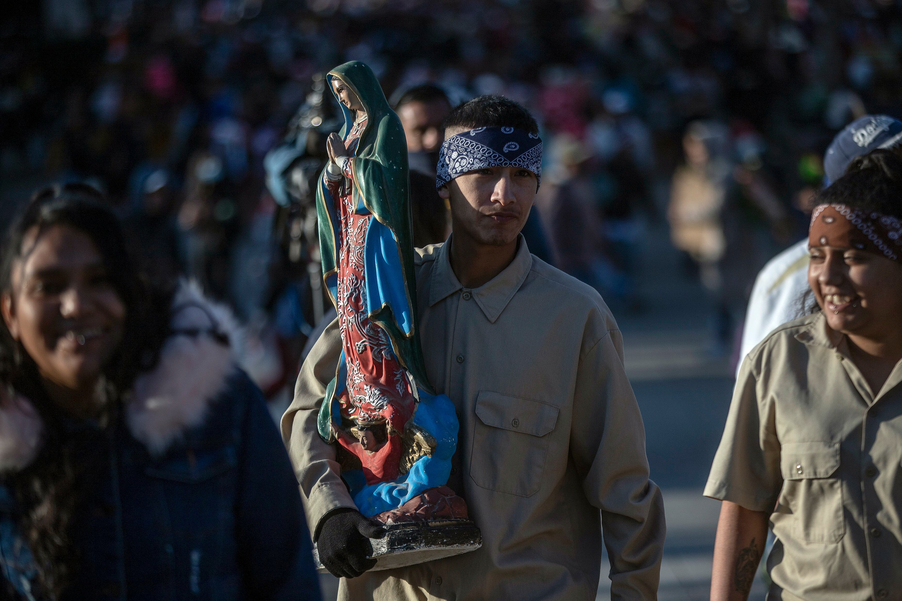 Un hombre sostiene una figura de la virgen a su llegada al atrio guadalupano para festejar los 491 años de la aparición de la Virgen de Guadalupe, en Ciudad de México (México).