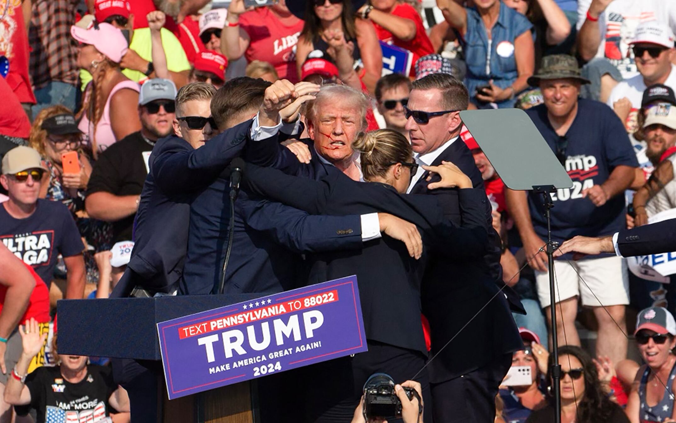 Donald Trump es rodeado de agentes del servicio secreto cuando lo sacan del escenario en un evento de campaña en Butler Farm Show Inc. en Butler, Pensilvania(Foto: Rebecca DROKE / AFP)