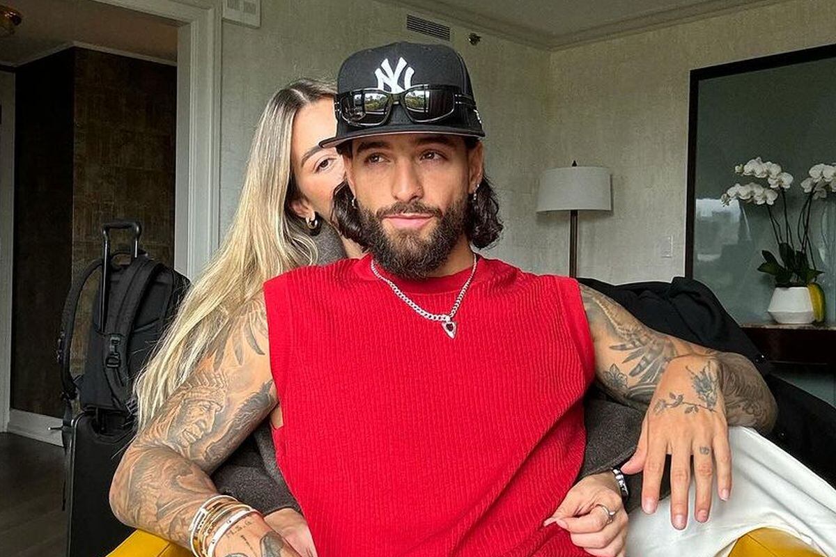El colombiano posando para la cámara y detrás haciendo un gesto con la mano está su novia Susana Gómez (Foto: Maluma / Instagram)