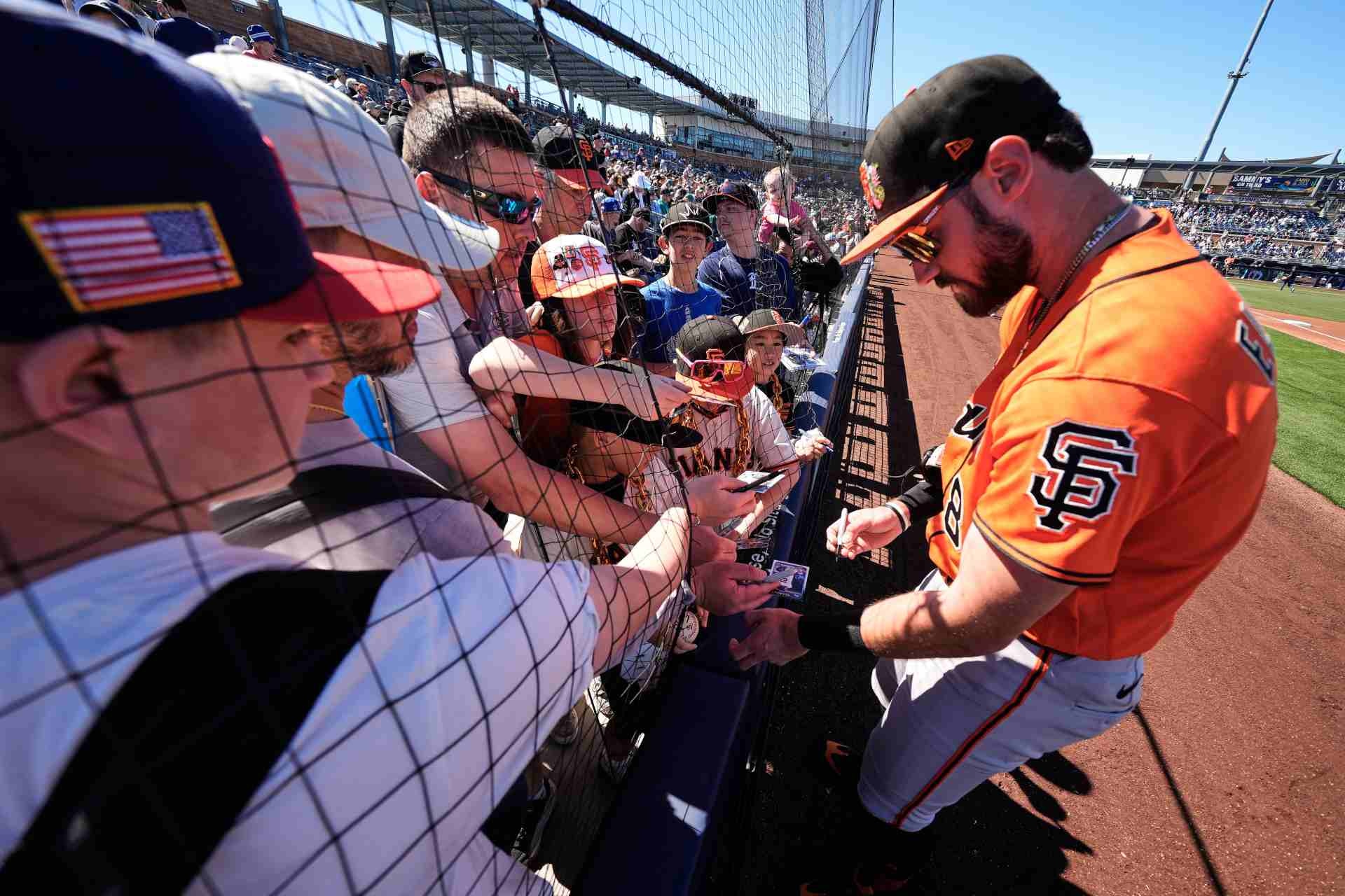 Bryce Eldridge, de los Gigantes de San Francisco, firma autógrafos previo al partido contra los Marineros de Seattle en los campamentos de primavera el sábado 21 de febrero de 2026, en Peoria, Arizona. (AP Foto/Charlie Riedel)