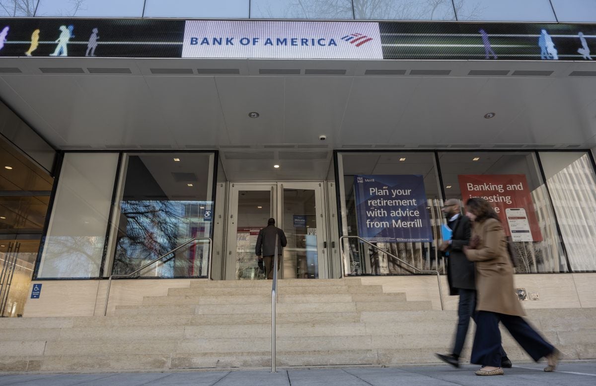 La gente pasa frente a una sucursal de Bank of America cuando un cliente ingresa en Washington, DC, el 14 de marzo de 2023. (Foto de ANDREW CABALLERO-REYNOLDS / AFP)